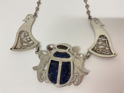 Lot 14 - Egyptian white metal and blue stone scarab beetle pendant necklace with pierced and carved white metal panels depicting birds and Egyptian figures