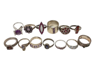 Lot 17 - Thirteen silver / white metal gem set rings including garnets, amethysts, opal etc