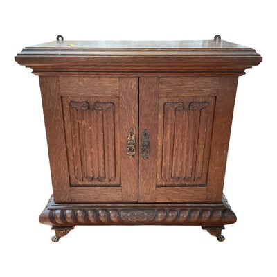 Lot 5177 - Small oak carved cabinet with carved panel doors, gadrooned lower molding above brass paw feet, the interior with three drawers and top section divided by columns, 43.5xm high x 44cm wide