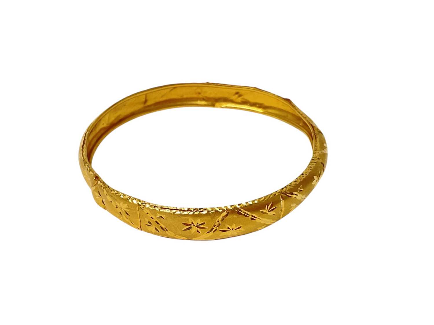 Lot 21 - Eastern 22ct gold bangle with engraved decoration