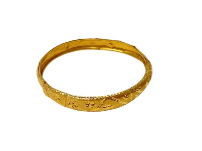 Lot 21 - Eastern 22ct gold bangle with engraved decoration