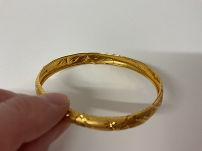 Lot 21 - Eastern 22ct gold bangle with engraved decoration