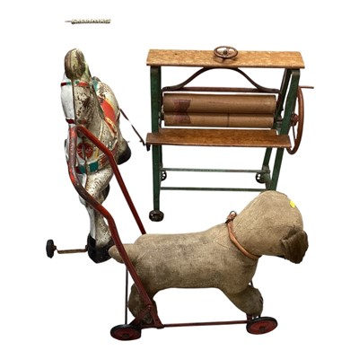 Lot 5204 - Group of vintage children's toys, including a Mobo tinplate pony, a push along dog and pony, dolls pram, chair and wrought metal cot