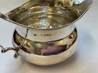 Lot 132 - Edwardian silver cream jug and a 1920s silver two handled trophy with presentation engraving