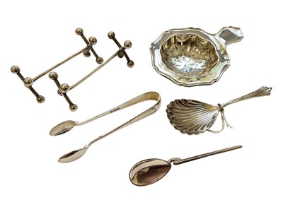 Lot 133 - Group of silver to include a tea strainer, Edwardian caddy spoon, pair of sugar tongs, coffee spoon and a pair of knife rests