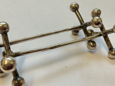 Lot 133 - Group of silver to include a tea strainer, Edwardian caddy spoon, pair of sugar tongs, coffee spoon and a pair of knife rests