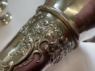 Lot 86 - Edwardian silver spill vase with embossed floral scroll decoration, silver napkin ring and a silver pepperette with weighted base (3)