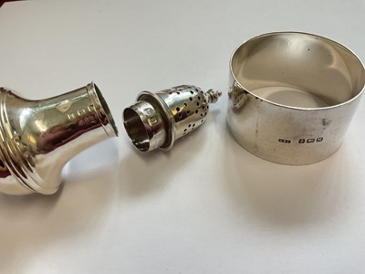 Lot 86 - Edwardian silver spill vase with embossed floral scroll decoration, silver napkin ring and a silver pepperette with weighted base (3)