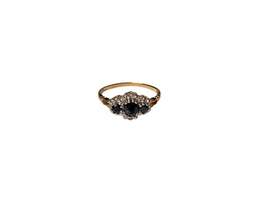 Lot 71 - Sapphire and diamond ring with three round mixed cut blue sapphires surrounded by a border of diamonds in 9ct gold setting