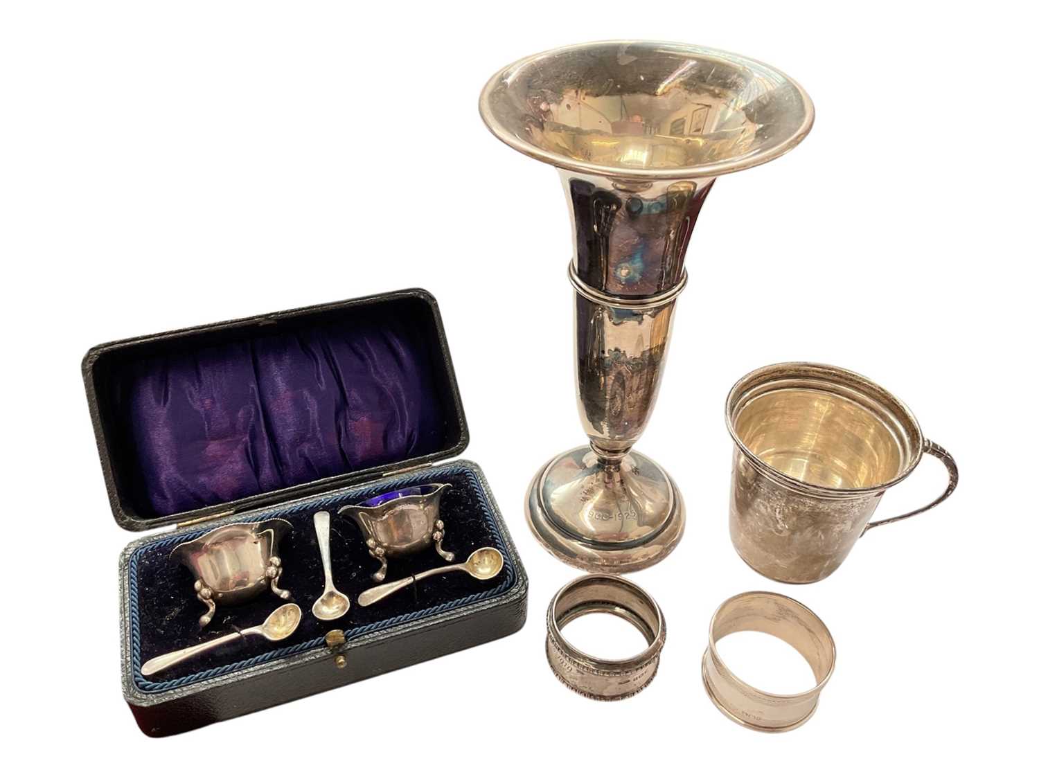 Lot 144 - Group of silver to include a pair of salts with three salt spoons in fitted case, two napkin rings, 1940s cup and a 1920s spill vase with weighted base
