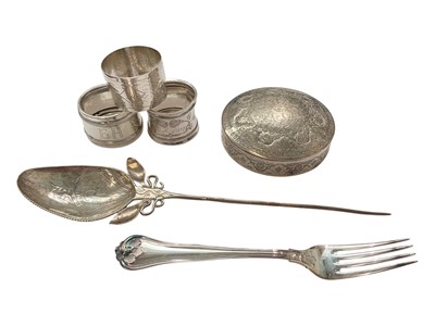 Lot 145 - Eastern white metal pot and cover with enrgaved foliate scroll decoration, Eastern white metal serving spoon, two silver (830) napkin rings, a plated napkin ring and a silver (830) fork