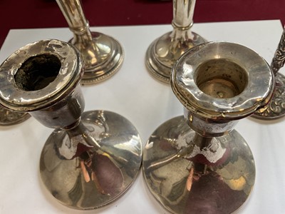 Lot 84 - Pair of late Victorian silver spill vases with embossed foliate scroll decoration, another pair of silver spill vases and a pair for silver candlesticks
