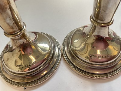 Lot 84 - Pair of late Victorian silver spill vases with embossed foliate scroll decoration, another pair of silver spill vases and a pair for silver candlesticks
