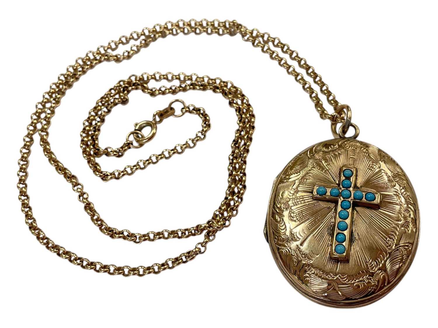 Lot 104 - Victorian gilt metal oval locket with a turquoise set cross and engraved scroll decoration, on a 9ct gold chain