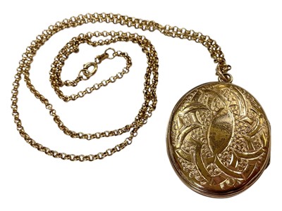 Lot 104 - Victorian gilt metal oval locket with a turquoise set cross and engraved scroll decoration, on a 9ct gold chain