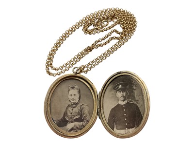 Lot 104 - Victorian gilt metal oval locket with a turquoise set cross and engraved scroll decoration, on a 9ct gold chain