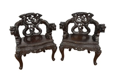 Lot 1355 - Pair of late 19th century Japanese Meiji period carved wooden chairs, elaborately carved with entwined dragons, dragon's head arms on carved cabriole legs