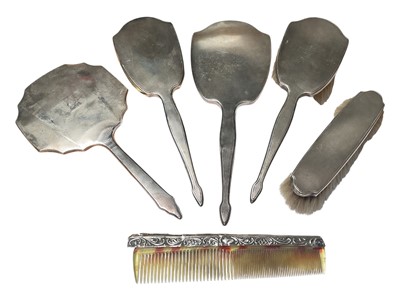 Lot 100 - 1930s silver mounted four piece dressing table set, together with another silver backed hand mirror and silver mounted comb (6)