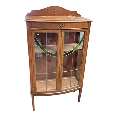 Lot 5387 - Edwardian oak bow front display cabinet with leaded and stained glass doors.