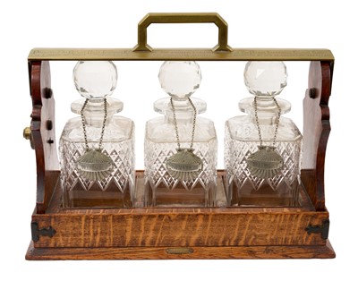 Lot 890 - Late 19th century oak and brass cased tantalus by Benetfink & Co. Cheapside, London, with Betjemann's patent lock, typical form with three cut glass decanters and stoppers, engraved to Rober...