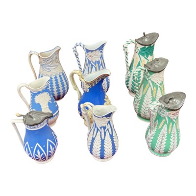 Lot 75 - Collection of Victorian relief moulded pottery jugs, mostly decorated with a foliate pattern on blue and green grounds (9)