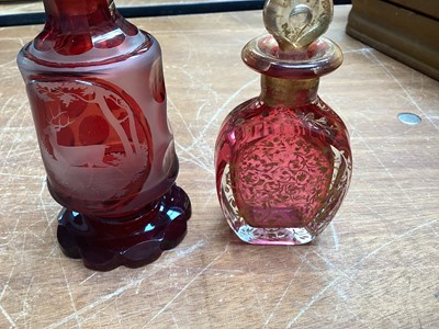 Lot 5076 - Victorian gilded cranberry scent bottle measuring 12cm tall together with a Bohemian red overlay hand engraved scent bottle measuring 16cm tall