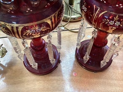 Lot 5102 - Pair of Bohemian ruby red lustres with prismatic drops, enamelled and gilt floral decoration, 27cm high