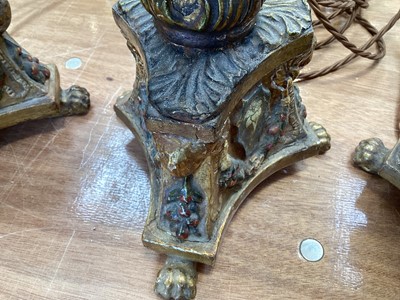Lot 5107 - Three Italian giltwood and gesso candlesticks, converted to lamps, the central columns supported by shells, on triangular bases with crests, the bases on paw feet, 27.5cm high excluding light fi...