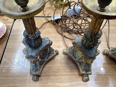 Lot 5107 - Three Italian giltwood and gesso candlesticks, converted to lamps, the central columns supported by shells, on triangular bases with crests, the bases on paw feet, 27.5cm high excluding light fi...