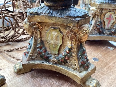 Lot 5107 - Three Italian giltwood and gesso candlesticks, converted to lamps, the central columns supported by shells, on triangular bases with crests, the bases on paw feet, 27.5cm high excluding light fi...