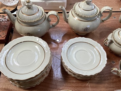 Lot 5112 - Rorstrand Swedish cream and gilt tea set, the rims with raised scroll pattern, comprising three teapots, two sugar bowls and one cover, 11 side plates, 15 saucers, and 21 cups
