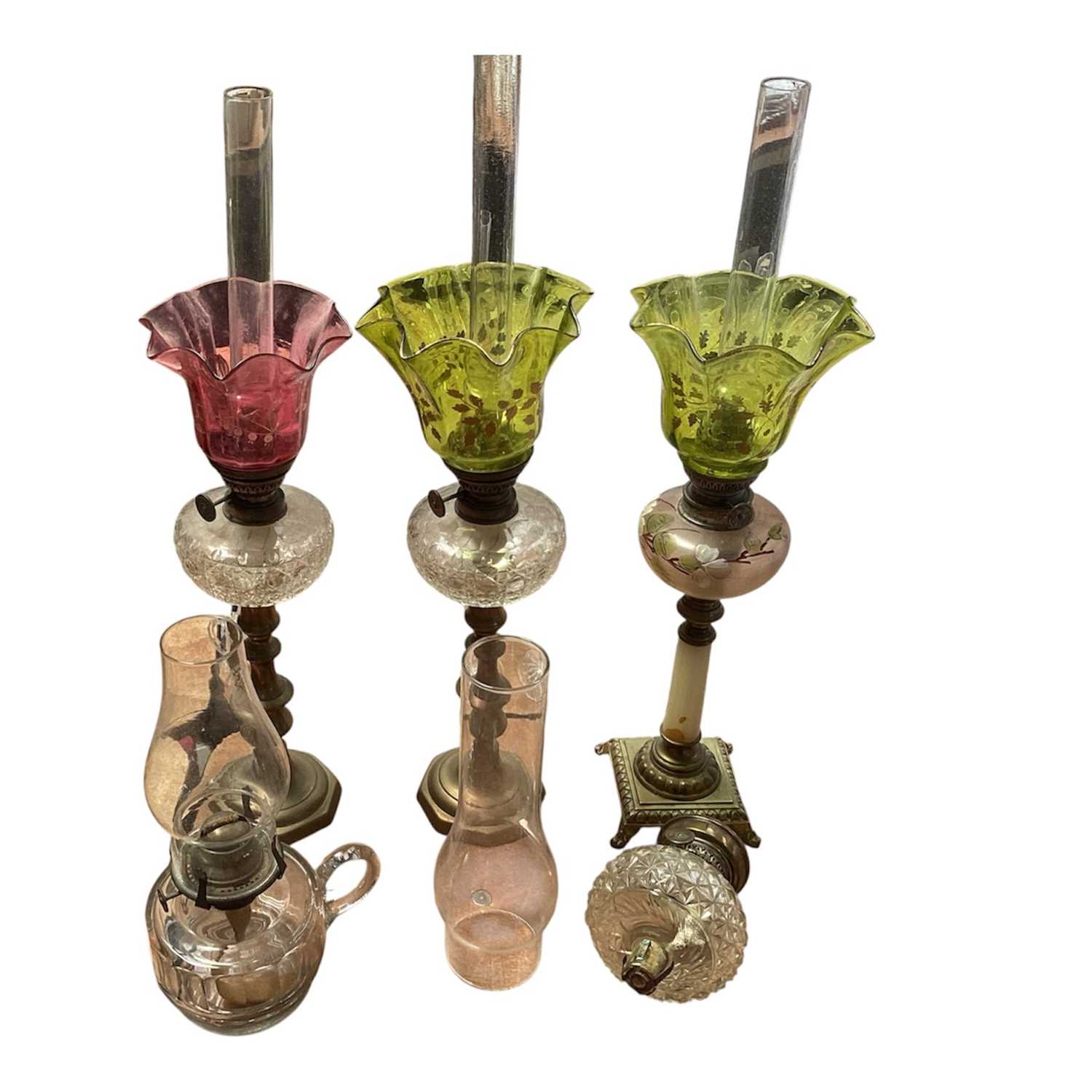 Lot 5119 - Three antique oil lamps with coloured glass shades, two of the burners by Gaudard France, and the other Kosmos, each approx 40cm high excluding chimneys, together with other oil lamp parts