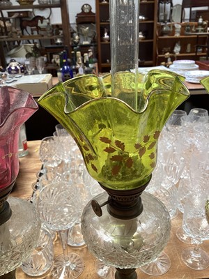 Lot 5119 - Three antique oil lamps with coloured glass shades, two of the burners by Gaudard France, and the other Kosmos, each approx 40cm high excluding chimneys, together with other oil lamp parts