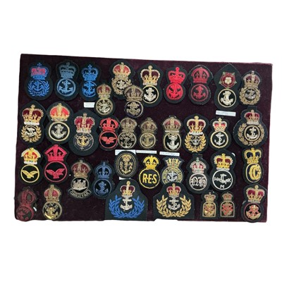 Lot 720 - Collection of thirty eight early 20th century and later Royal Navy badges, mounted on a velvet board, (38).