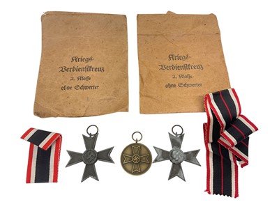 Lot 707 - Two Second World War Nazi German War Merit Cross medals (without swords), together with a Nazi German War Merit medal and two original envelopes.