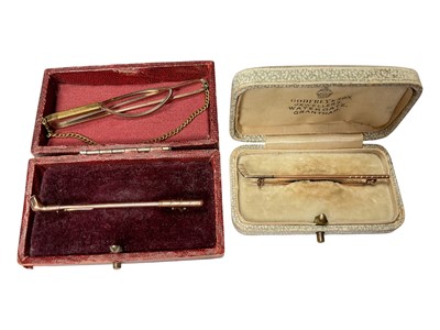 Lot 123 - Two gold golf club stick pins and a plated tie clip (3)