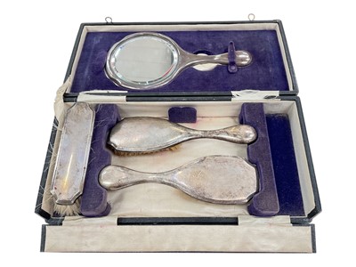 Lot 181 - George V silver four piece hand mirror and brush set (Birmingham 1928) in a velvet lined fitted case