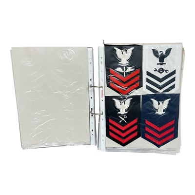 Lot 748 - Collection of mainly Royal Navy cloth badges, together with some cap badges, pin badges and others, contained within a ring binder album.