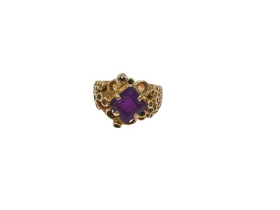 Lot 213 - 1960s/70s yellow metal amethyst cocktail ring with rectangular step cut purple amethyst in four claw setting in a textured abstract yellow metal setting, size L