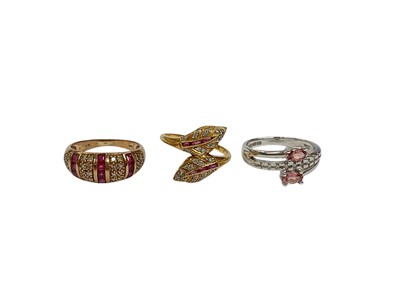 Lot 216 - 9ct gold ruby and diamond bombé ring, size K, yellow metal (stamped 850) ruby and diamond double leaf cross-over ring, size K and 9ct white gold pink stone and diamond ring, size M (3)