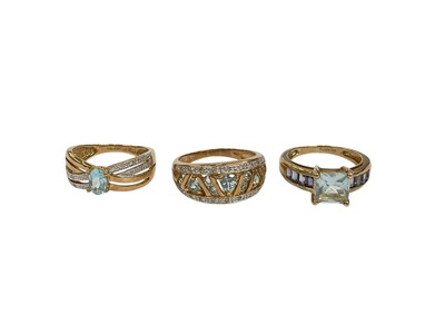 Lot 217 - Three 9ct gold blue topaz dress rings to include a topaz single stone ring with a diamond set cross-over band, size M½, another topaz and diamond ring, size O½ and a topaz and amethyst ring, siz...