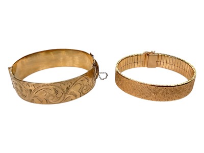 Lot 194 - Vintage 9ct gold metal cored hinged bangle with engraved scroll decoration, together with a gold plated articulated link bracelet (2)