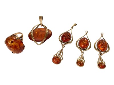 Lot 240 - 9ct gold mounted amber jewellery to include three matching pendant drops, one other pendant and a ring