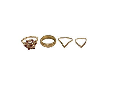 Lot 279 - 9ct gold garnet flower head cluster ring, 9ct gold wedding ring, 9ct gold wishbone ring and another yellow metal (4)