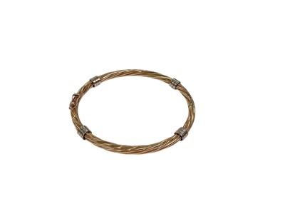 Lot 282 - 9ct gold twisted design hinged bangle with white gold spacers