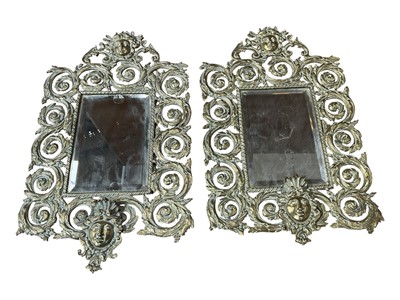 Lot 5136 - Pair of brass mirrors with masks and scrolling foliage, 42cm x 26cm