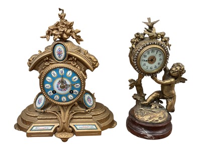 Lot 22 - Antique French ormolu clock depicting Cupid, the enamel dial with paste-set surround, on red marble base, 28cm high, together with another similar clock with Sevres style painted panels (2)