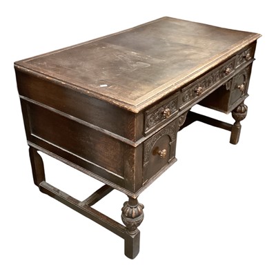 Lot 1385 - 1930's Jacobean revival carved oak kneehole desk with five drawers on cup and cover supports, 121cm wide, 68cm deep, 76cm high