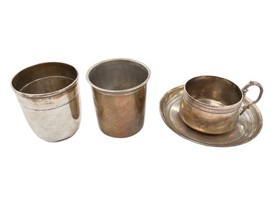 Lot 1007 - Two French silver beakers and a French white metal tea cup and saucer (4)