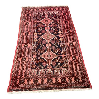 Lot 1418 - Eastern rug rug with three central medallions on red and black ground, 200cm x 102cm, together with another rug, 181cm x 119cm (2)